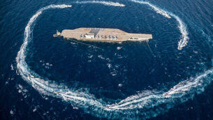 In this photo released Tuesday, July 28, 2020, by Sepahnews, Revolutionary Guard's speed boats circle around a replica aircraft carrier during a military exercise. Iran’s paramilitary Revolutionary Guard has fired a missile from a helicopter targeting the mock-up aircraft carrier in the strategic Strait of Hormuz. That's according to footage aired on state television on Tuesday. Iranian commandos also fast-roped down from a helicopter onto the replica in the footage from the exercise called “Great Prophet 14.” The drill appears aimed at threatening the U.S. amid tensions between Tehran and Washington. (Sepahnews via AP)