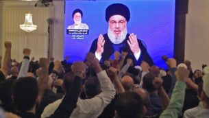 Supporters of Hassan Nasrallah, the head of Lebanon's militant Shiite Muslim Hezbollah movement, watch him speak through a giant screen at a mosque in the Lebanese capital Beirut's southern suburbs on November 1, 2019. (Photo by - / AFP)