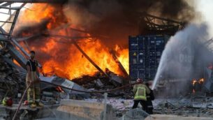 Firefighter douse a blaze at the scene of an explosion at the port of Lebanon's capital Beirut on August 4, 2020. - Two huge explosion rocked the Lebanese capital Beirut, wounding dozens of people, shaking buildings and sending huge plumes of smoke billowing into the sky. Lebanese media carried images of people trapped under rubble, some bloodied, after the massive explosions, the cause of which was not immediately known. (Photo by STR / AFP)