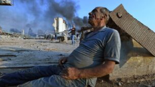 A wounded man sits on the ground waiting for aid at Beirut's port following a massive explosion that hit the heart of the Lebanese capital on August 4, 2020. - Rescuers searched for survivors in Beirut on August 5 after a cataclysmic explosion at the port sowed devastation across entire neighbourhoods, killing more than 100 people, wounding thousands and plunging Lebanon deeper into crisis. (Photo by - / AFP)