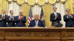 President Donald Trump, accompanied by F=from left, U.S. special envoy for Iran Brian Hook, Avraham Berkowitz, Assistant to the President and Special Representative for International Negotiations, U.S. Ambassador to Israel David Friedman, President Donald Trump's White House senior adviser Jared Kushner, and Treasury Secretary Steven Mnuchin, applaud in the Oval Office at the White House, Wednesday, Aug. 12, 2020, in Washington. Trump said on Thursday that the United Arab Emirates and Israel have agreed to establish full diplomatic ties as part of a deal to halt the annexation of occupied land sought by the Palestinians for their future state. (AP Photo/Andrew Harnik)