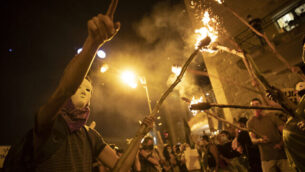 Protesters light torches during a protest against Israel's Prime Minister Benjamin Netanyahu outside his residence in Jerusalem, Saturday, Aug 1, 2020. Protesters demanded that the embattled Israeli leader to resign as he faces a trial on corruption charges and grapples with a deepening coronavirus crisis. (AP Photo/Oded Balilty)