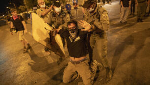 Police clear off protesters who blocked a main road during a protest against Israel's Prime Minister Benjamin Netanyahu outside his residence in Jerusalem, early Sunday, Aug 2, 2020. Protesters demanded that the embattled Israeli leader resign as he faces a trial on corruption charges and grapples with a deepening coronavirus crisis. (AP Photo/Oded Balilty)