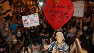 Thousands protest against Israel's Prime Minister Benjamin Netanyahu in front of his official residence in Jerusalem, Saturday, Aug. 8, 2020.   (AP Photo/Ariel Schalit)