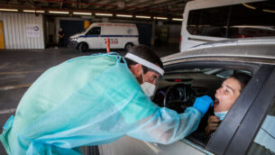 Shaare Zedek Medical team member wearing protective gear takes a swab from a woman to test for the coronavirus disease (COVID-19), outside the coronavirus unit at Shaare Zedek hospital in Jerusalem on September 14, 2020. Photo by Nati Shohat/Flash90 ***
