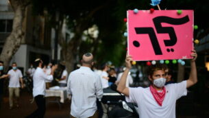A man protest against Israeli prime minister Benjamin Netanyahu during Simchat Torah celebrations in Tel Aviv on October 10, 2020. Photo by Tomer Neuberg/Flash90 *** Local Caption ***
