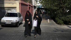 دو زن ایرانی چادری حین عبور از خیابانی در مرکز شهر تهران