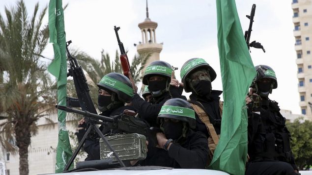 عاملان ماسکدار تیپ عزالدین القاسم، شاخه‌ی نظامی گروه تروریستی حماس، سوار بر وسایل نقلیه در بزرگداشت سی‌امین سالگرد تأسیس گروه، در شهر غزه، ۱۳ دسامبر ۲۰۱۷. (AP Photo/Adel Hana)