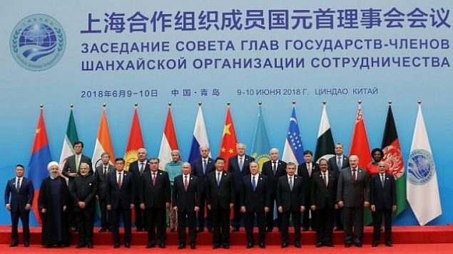 توضیح تصویر: حسن روحانی رئیس جمهور ایران، چپ، پایین، و شی جینپینگ رئیس جمهور چین، چپ، بالا، با دیگر رهبران جهانی در مقابل دوربین عکاسان در شورای رهبران دول سازمان همکاریهای شانگهای در کینگداو، ۱۰ ژوئن ۲۰۱۸. AFP PHOTO / Sputnik / Mikhail METZEL)) توضیح تصویر: حسن روحانی رئیس جمهور ایران، چپ، پایین، و شی جینپینگ رئیس جمهور چین، چپ، بالا، با دیگر رهبران جهانی در مقابل دوربین عکاسان در شورای رهبران دول سازمان همکاریهای شانگهای در کینگداو، ۱۰ ژوئن ۲۰۱۸. AFP PHOTO / Sputnik / Mikhail METZEL))
