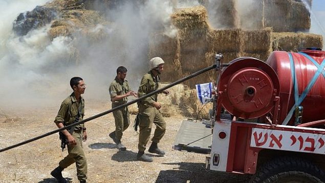 توضیح تصویر: آتش نشان ها و گروه های ایمنی هنگام تلاش در فرونشاندن آتش در طویله ای در گاوداری که با بادبادکی حامل مواد منفجره از غزه ایجاد شد، کیبوتص نهال-اوز، 21 ژوئن 2018. (Gili Yaari/FLASH90) توضیح تصویر: آتش نشان ها و گروه های ایمنی هنگام تلاش در فرونشاندن آتش در طویله ای در گاوداری که با بادبادکی حامل مواد منفجره از غزه ایجاد شد، کیبوتص نهال-اوز، 21 ژوئن 2018. (Gili Yaari/FLASH90)