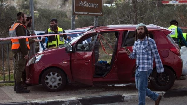 تصویر: کارکنان پزشکی قانونی اسرائیل اتوموبیلی در حوالی محل حمله در نزدیکی تقاطع آریل در کرانه باختری را مورد تجسس قرار داده اند، ۱۷ مارس ۲۰۱۹. (JAAFAR ASHTIYEH / AFP)