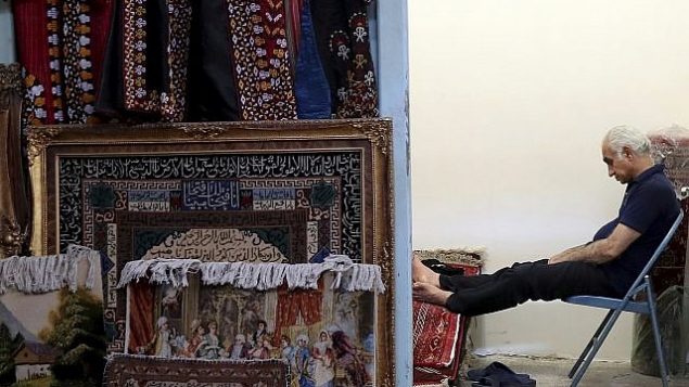 تصویر: یک قالی فروش در بازار قدیم تهران، تهران، ۲۳ ژوئن ۲۱۹. (AP Photo/Ebrahim Noroozi)