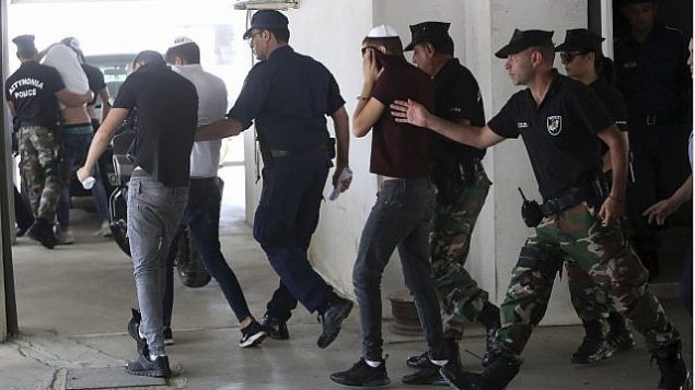 تصویر: مظنونین اسرائیلی هنگام ورود به دادگاه «فماگوستا« در «پارالامنی» قبرس، چهره خود را با تی-شرت‌های خود پوشانده اند، ۲۶ ژوئیه ۲۰۱۹. (AP Photo/Petros Karadjias)