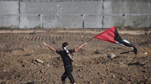 تصویر: یک تظاهرکننده جوان با پرچم فلسطینی هنگام تظاهرات در کنار حصار مرزی اسرائیل با شرق شهر غزه، ۴ اکتبر ۲۰۱۹. (MAHMUD HAMS / AFP) تصویر: یک تظاهرکننده جوان با پرچم فلسطینی هنگام تظاهرات در کنار حصار مرزی اسرائیل با شرق شهر غزه، ۴ اکتبر ۲۰۱۹. (MAHMUD HAMS / AFP)
