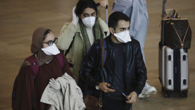 Passengers wearing masks to help protect against coronavirus arrive at the Ben Gurion Airport near Tel Aviv, Israel, Tuesday, March 10, 2020. Israel will quarantine anyone arriving from overseas for 14 days, a decision coming barely a month before Easter and Passover. According to the World Health Organization, people with mild illness recover in about two weeks, while those with more severe illness may take three to six weeks to recover. (AP Photo/Ariel Schalit) Passengers wearing masks to help protect against coronavirus arrive at the Ben Gurion Airport near Tel Aviv, Israel, Tuesday, March 10, 2020. Israel will quarantine anyone arriving from overseas for 14 days, a decision coming barely a month before Easter and Passover. According to the World Health Organization, people with mild illness recover in about two weeks, while those with more severe illness may take three to six weeks to recover. (AP Photo/Ariel Schalit)