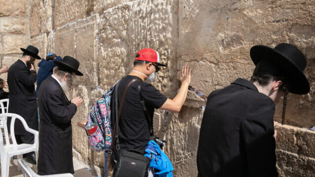 An American tourist wearing a face mask for fear of the coronavirus, prays at the Western Wall in the Old City of Jerusalemon February 27, 2020. Photo by Olivier Fitoussi/Flash90 *** Local Caption *** וירוס
קורונה
מגפה
סין
שדה תעופה An American tourist wearing a face mask for fear of the coronavirus, prays at the Western Wall in the Old City of Jerusalemon February 27, 2020. Photo by Olivier Fitoussi/Flash90 *** Local Caption *** וירוס
קורונה
מגפה
סין
שדה תעופה