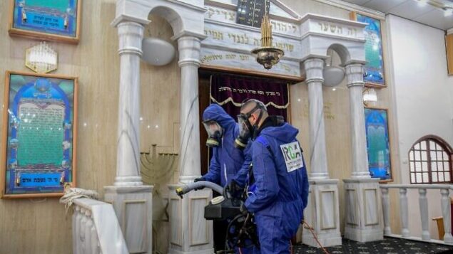 Workers wearing protective clothes disinfect a synagogue in Bat Yam, on March 18, 2020, as part of measures to prevent the spread of the Coronavirus. Photo by Flash90 *** Local Caption *** ÷åøåðä
åéøåñ
áú éí
áéú ëðñú
òåáãéí
áðééï
çéèåé Workers wearing protective clothes disinfect a synagogue in Bat Yam, on March 18, 2020, as part of measures to prevent the spread of the Coronavirus. Photo by Flash90 *** Local Caption *** ÷åøåðä
åéøåñ
áú éí
áéú ëðñú
òåáãéí
áðééï
çéèåé