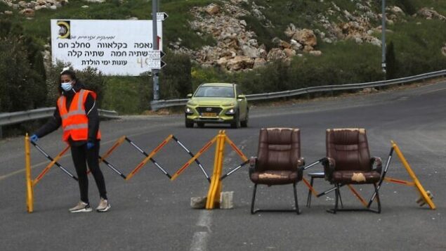 A woman stands next to a makeshift checkpoint, part of a community safety initiative in the Druze village of Majdal Shams in the Israel-annexed Golan Heights on April 9, 2020, amid the novel coronavirus epidemic. (Photo by JALAA MAREY / AFP) A woman stands next to a makeshift checkpoint, part of a community safety initiative in the Druze village of Majdal Shams in the Israel-annexed Golan Heights on April 9, 2020, amid the novel coronavirus epidemic. (Photo by JALAA MAREY / AFP)
