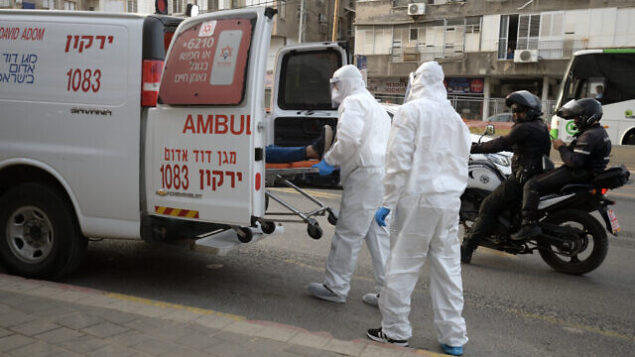 Israeli Magen David Adom medical team members transfer an Israeli man, suspected of being Covid-19 positive, in the Ultra-Orthodox Jewish city of Bnei Brak, March 31, 2020. Photo by Gili Yaari/Flash90 *** Local Caption *** קורונה וירוס מגיפה בדיקות נשאים סגר הסגר חרדים חולים נשאים אמבולנס פינוי חולה Israeli Magen David Adom medical team members transfer an Israeli man, suspected of being Covid-19 positive, in the Ultra-Orthodox Jewish city of Bnei Brak, March 31, 2020. Photo by Gili Yaari/Flash90 *** Local Caption *** קורונה וירוס מגיפה בדיקות נשאים סגר הסגר חרדים חולים נשאים אמבולנס פינוי חולה