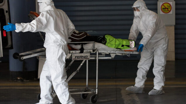 Magen David Adom workers wearing protective clothing, as a preventive measure against the coronavirus evacuate a patient with suspicion to coronavirus outside the new coronavirus unit at Shaare Zedek hospital in Jerusalem on April 3, 2020. Photo by Nati Shohat/Flash90 *** Local Caption *** קורונה
בית חולים
שערי צדק
וירוס Magen David Adom workers wearing protective clothing, as a preventive measure against the coronavirus evacuate a patient with suspicion to coronavirus outside the new coronavirus unit at Shaare Zedek hospital in Jerusalem on April 3, 2020. Photo by Nati Shohat/Flash90 *** Local Caption *** קורונה
בית חולים
שערי צדק
וירוס