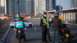 Israeli police officers and Israeli soldiers close Begin road, near the entrance to Ramat Gan in Tel Aviv.  April 14, 2020. All intercity travel has been banned until Thursday morning. Photo by Miriam Alster/Flash90 *** Local Caption *** תל אביב
איילון
סגר
חיילים
שוטרים