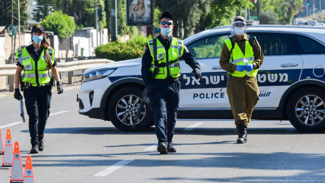 Israeli police and soldiers guard at a roadblock on a road leading to Kiryat Shaul Military Cemetery, as Israel marks Memorial Day for the fallen soldiers and victims of terror on April 28, 2020. This year, due to the outbreak of the Coronavirus, there will be restrictions on going to the cemeteries on Memorial Day itself. Photo by Avshalom Sassoni/Flash90 *** Local Caption *** יום הזיכרון
בית קברות
חיילים
דגלים
חללים
קרית שאול
מחסום
משטרה
חיילים
זיכרון
בית קברות Israeli police and soldiers guard at a roadblock on a road leading to Kiryat Shaul Military Cemetery, as Israel marks Memorial Day for the fallen soldiers and victims of terror on April 28, 2020. This year, due to the outbreak of the Coronavirus, there will be restrictions on going to the cemeteries on Memorial Day itself. Photo by Avshalom Sassoni/Flash90 *** Local Caption *** יום הזיכרון
בית קברות
חיילים
דגלים
חללים
קרית שאול
מחסום
משטרה
חיילים
זיכרון
בית קברות