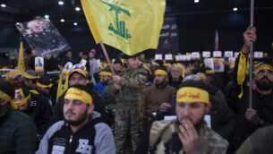 A child in tiny military fatigues waves the Hezbollah flag as supporters of the group's leader Sayyed Hassan Nasrallah wait for his televised speech in a southern suburb of Beirut, Lebanon, Sunday, Jan. 5, 2020 (AP Photo/Maya Alleruzzo)