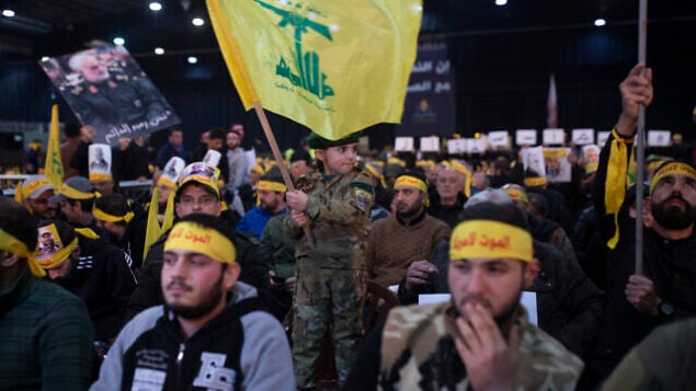 A child in tiny military fatigues waves the Hezbollah flag as supporters of the group's leader Sayyed Hassan Nasrallah wait for his televised speech in a southern suburb of Beirut, Lebanon, Sunday, Jan. 5, 2020 (AP Photo/Maya Alleruzzo)