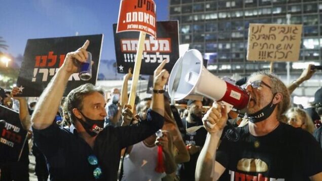 Israelis lift placards and chant slogans during a demonstration in Rabin Square in the central coastal city of Tel Aviv, on July 11, 2020, to protest the government's abandonment of the country's self-employed and other sectors after forcing their businesses to close under COVID-19 regulations, according to the organizers. (Photo by Jack GUEZ / AFP) Israelis lift placards and chant slogans during a demonstration in Rabin Square in the central coastal city of Tel Aviv, on July 11, 2020, to protest the government's abandonment of the country's self-employed and other sectors after forcing their businesses to close under COVID-19 regulations, according to the organizers. (Photo by Jack GUEZ / AFP)