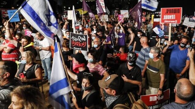 Anti-government protesters, clad in masks due to the COVID-19 coronavirus pandemic, gather with Israeli flags and signs during a demonstration in Charles Clore Park in the Mediterranean coastal city of Tel Aviv on July 18, 2020, against the Israeli government for broken promises made during the novel coronavirus pandemic. (Photo by Jack GUEZ / AFP) Anti-government protesters, clad in masks due to the COVID-19 coronavirus pandemic, gather with Israeli flags and signs during a demonstration in Charles Clore Park in the Mediterranean coastal city of Tel Aviv on July 18, 2020, against the Israeli government for broken promises made during the novel coronavirus pandemic. (Photo by Jack GUEZ / AFP)
