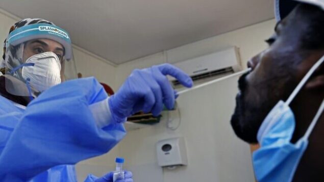 An Israeli medic collects a swab sample from a man at a COVID-19 testing facility in the Israeli city of Or Yehuda on July 22, 2020. (Photo by JACK GUEZ / AFP) An Israeli medic collects a swab sample from a man at a COVID-19 testing facility in the Israeli city of Or Yehuda on July 22, 2020. (Photo by JACK GUEZ / AFP)