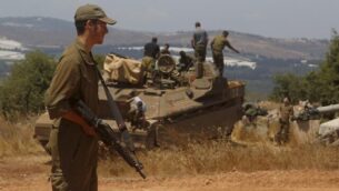 An Israeli soldier stands near a Namer IFV (Infantry Fighting Vehicle) near the town of Avivim in northern Israeli along the border with Lebanon on July 23, 2020. (Photo by JALAA MAREY / AFP)