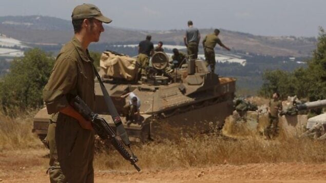 An Israeli soldier stands near a Namer IFV (Infantry Fighting Vehicle) near the town of Avivim in northern Israeli along the border with Lebanon on July 23, 2020. (Photo by JALAA MAREY / AFP) An Israeli soldier stands near a Namer IFV (Infantry Fighting Vehicle) near the town of Avivim in northern Israeli along the border with Lebanon on July 23, 2020. (Photo by JALAA MAREY / AFP)