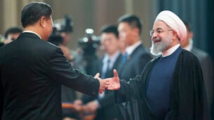 Chinese President Xi Jinping, left, greets Iranian President Hassan Rouhani at the Shanghai Cooperation Organization (SCO) Summit in Qingdao in eastern China's Shandong Province, Sunday, June 10, 2018. China will seek to further promote its economic links with Central Asia during this weekend's summit of the China and Russia-dominated SCO. (AP Photo/Alexander Zemlianichenko)