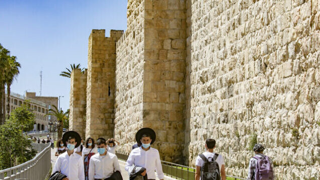 Jerusalemites wearing protective mask walk near the Jaffa Gate in the Old City of Jerusalem on June 23, 2020. Israel has seen a spike of new COVID-19 cases bringing fears of a “second wave”, hospitals around the country might prepare to reopen their Covid units.
Photo by Olivier Fitoussi/Flash90 *** Local Caption *** ירושלים
קורונה 
וירוס
יפו
שער
העיר העתיקה
מירכז העיר