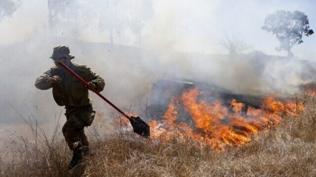 An Israeli soldier battles a blaze in a field close to the southern Israeli kibbutz of Nir Am near the border with the Gaza Strip on August 23, 2020, after it was reportedly set off by incendiary kites flown from the Palestinian enclave. (Photo by menahem kahana / AFP) An Israeli soldier battles a blaze in a field close to the southern Israeli kibbutz of Nir Am near the border with the Gaza Strip on August 23, 2020, after it was reportedly set off by incendiary kites flown from the Palestinian enclave. (Photo by menahem kahana / AFP)