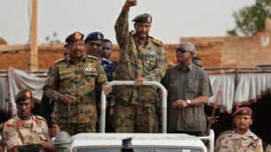 Sudanese Gen. Abdel-Fattah Burhan, head of the military council, waves to his supporters upon his arrival to attend a military-backed rally, in Omdurman district, west of Khartoum, Sudan, Saturday, June 29, 2019. Sudan's ruling military council on Saturday warned protest leaders of "destruction or damage" ahead of planned mass rallies over the weekend calling for civilian rule over two months after the military ouster of autocratic president Omar al-Bashir. (AP Photo/Hussein Malla)