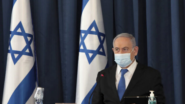 Israeli Prime Minister Benjamin Netanyahu wears a face mask to help prevent the spread of the coronavirus as he opens the weekly cabinet meeting, at the foreign ministry, in Jerusalem, Sunday, July 5, 2020. (Photo by Gali Tibbon/Pool via AP)