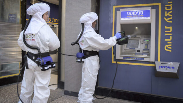 Cleaning workers disinfect an ATM at a bank in Ramat Gan.  June 3, 2020. Photo by Flash90 *** Local Caption *** çéèåé
áð÷