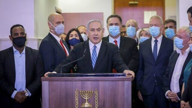 Israeli Prime Minister Benjamin Netanyahu delivers a statement before entering a courtroom at the district court of Jerusalem on May 24, 2020, during the first day of his corruption trial. - Fresh from forming a new government after more than 500 days of electoral deadlock, Netanyahu is expected to begin a new battle in the Jerusalem District Court -- to stay out of prison. The 70-year-old was scheduled to appear at a court hearing to formally confirm his identity to judges, after being indicted in January for bribery, fraud and breach of trust. (Photo by Yonathan SINDEL / POOL / AFP) Israeli Prime Minister Benjamin Netanyahu delivers a statement before entering a courtroom at the district court of Jerusalem on May 24, 2020, during the first day of his corruption trial. - Fresh from forming a new government after more than 500 days of electoral deadlock, Netanyahu is expected to begin a new battle in the Jerusalem District Court -- to stay out of prison. The 70-year-old was scheduled to appear at a court hearing to formally confirm his identity to judges, after being indicted in January for bribery, fraud and breach of trust. (Photo by Yonathan SINDEL / POOL / AFP)