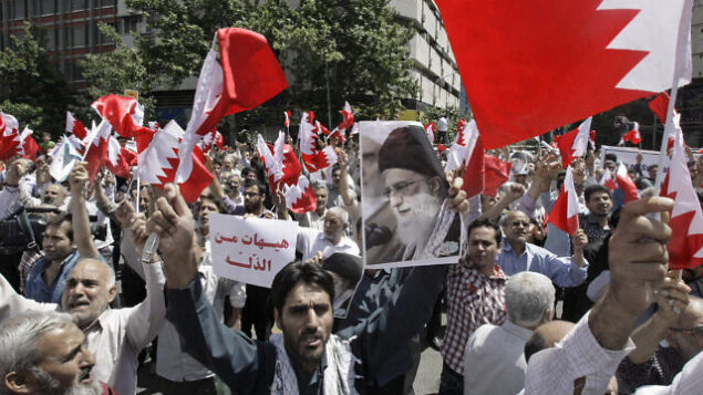 Iranians wave Bahraini flags as they chant slogans during a demonstration in Tehran, Iran, Friday, May 18, 2012. Iranians rallied Friday to denounce efforts by Bahrain's Sunni rulers to forge closer ties with Saudi Arabia, a pact the Shiite powerhouse Iran claims would go against the will of the tiny island nation's majority Shiites. A man holds a poster of Iranian supreme leader Ayatollah Ali Khamenei, center right, and Arabic on the poster, center left, reads, "enough of humiliation." (AP Photo/Vahid Salemi) Iranians wave Bahraini flags as they chant slogans during a demonstration in Tehran, Iran, Friday, May 18, 2012. Iranians rallied Friday to denounce efforts by Bahrain's Sunni rulers to forge closer ties with Saudi Arabia, a pact the Shiite powerhouse Iran claims would go against the will of the tiny island nation's majority Shiites. A man holds a poster of Iranian supreme leader Ayatollah Ali Khamenei, center right, and Arabic on the poster, center left, reads, "enough of humiliation." (AP Photo/Vahid Salemi)