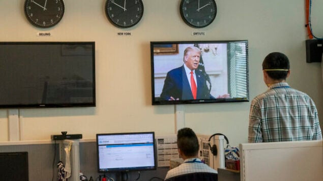 Reporters with the Xinhua Press Agency watch as U.S. President Donald Trump is seen on a video screen remotely addressing the 75th session of the United Nations General Assembly, Tuesday, Sept. 22, 2020, at U.N. headquarters. This year's annual gathering of world leaders at U.N. headquarters will be almost entirely "virtual." Leaders have been asked to pre-record their speeches, which will be shown in the General Assembly chamber, where each of the 193 U.N. member nations are allowed to have one diplomat present. (AP Photo/Mary Altaffer)
