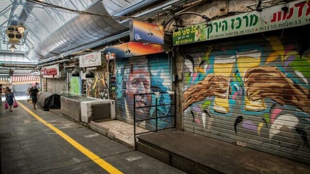 People wearing face masks shop at the Mahane Yehuda Market in Jerusalem on September 21, 2020, during a nationwide lockdown. Photo by Yonatan Sindel/Flash90 *** Local Caption ***