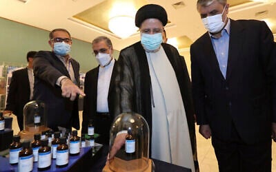 تصویر: در عکسی از وبسایت رسمی دفتر ریاست جمهوری ایران، ابراهیم رئیسی، رئیس جمهور رژیم ایران، دومی از راست، به تاریخ ۹ آوریل ۲۰۲۲،  در بازدید از نمایشگاه دستاوردهای هسته ای ایران در تهران حین استماع به توضیحاتی مشاهده می شود. (Iranian Presidency Office via AP)