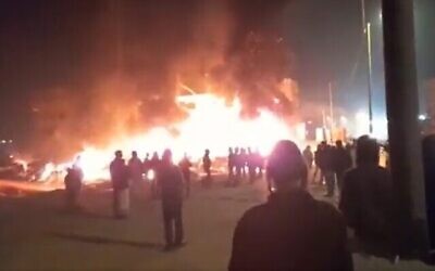 شهرک-نشینان در حال تماشای اتوموبیل-ها و خانه-هایی که خود در ۲۷ فوریهٔ ۲۰۲۳ در شهر هوآرای کرانهٔ باختری به آتش کشیده-اند. (Screenshot: Twitter; Used in accordance with Clause 27a of the Copyright Law)