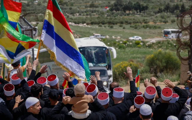 شرح عکس: روحانیون دروز در ۲۵ آوریل ۲۰۲۵، نزدیک روستای مجدل شمس در بلندیهای جولان، حین انتظار ورود همتایان خود که از سوریه با اتوبوس از طریق ناحیهٔ حائل مرزی که تحت نگهبانی سربازان است، وارد می شوند.
(Photo by Jalaa MAREY / AFP)