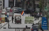 شرح عکس: بعد از درگیری در ناحیه، میان اعضای فرقهٔ اقلیت دروز و رزمندگان هوادار دولت، افراد مسلح، در ایست بازرسی یکی از ورودی های جرمانا، حومهٔ جنوبی دمشق، کنار پرچم مذهبی فرقهٔ خود ایستاده اند؛ دمشق، سوریه،۳۰ آوریل ۲۰۲۵. (AP Photo/Omar Sanadiki)