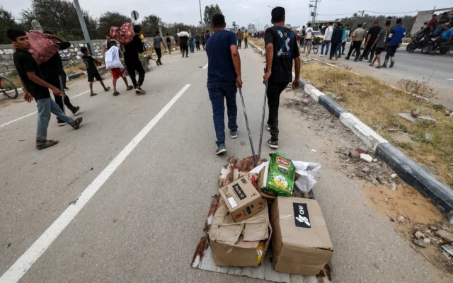 شرح عکس: آوارگان فلسطینی در ۸ ژوئن ۲۰۲۵، حین حمل کالای امداد در بازگشت از مرکز توزیع امداد در ناحیهٔ مرکزی نوار غزه، بنیاد امور بشردوستانهٔ غزه (GHF)، که یک گروه خصوصی امداد و تحت حمایت ایالات متحده است، دیده می شوند. Eyad BABA / AFP)