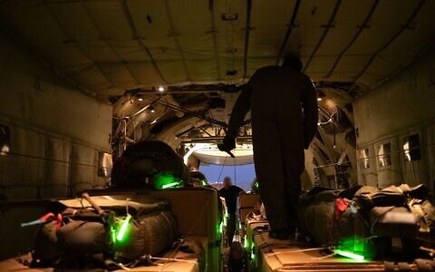 شرح عکس: یکی از کارکنان نیروی هوایی اسرائيل در ۲۶ ژوئیهٔ ۲۰۲۵، جعبه های امداد بشردوستانه را پیش از بارریزی هوایی در نوار غزه آماده می کند. (IDF)