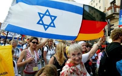 A titre d'illustration : Une chrétienne allemande brandit un drapeau israélo-allemand pendant la fête de Souccot à Jérusalem. (Crédit photo : Olivier Fitoussi/Flash90) A titre d'illustration : Une chrétienne allemande brandit un drapeau israélo-allemand pendant la fête de Souccot à Jérusalem. (Crédit photo : Olivier Fitoussi/Flash90)
